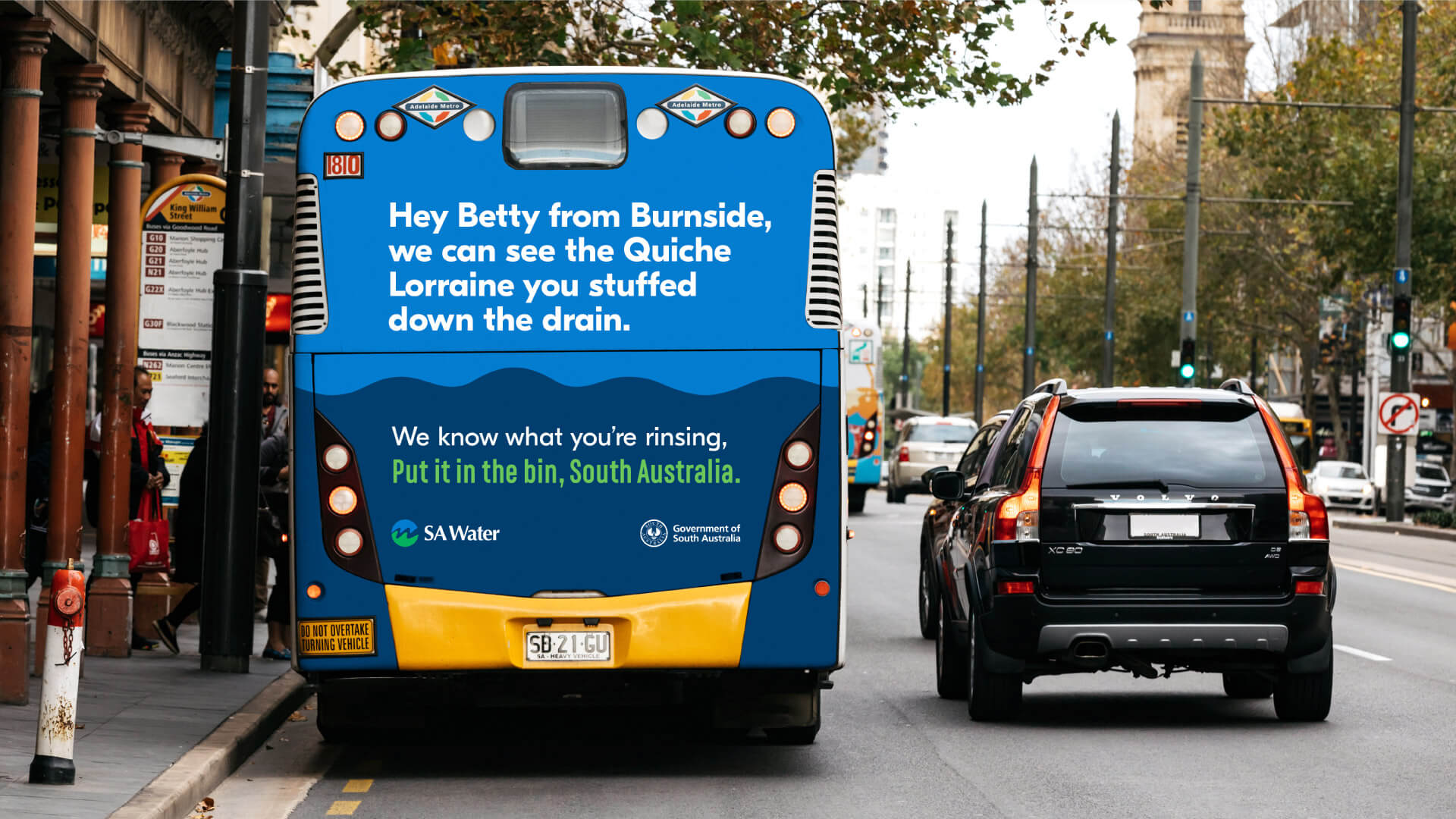 Copy on the back of a bus which reads 'Hey Betty from Burnside, we can see the Quiche Lorraine you stuffed down the drain.'